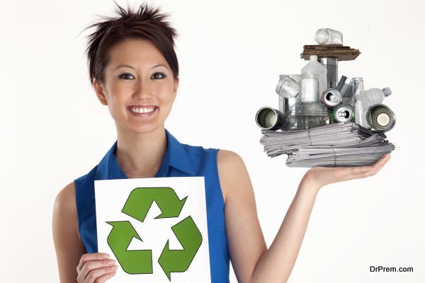 Pretty Asian Woman holding up a Recycle sign and recyclables