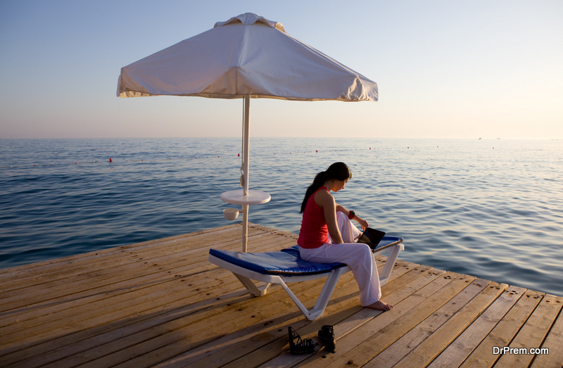 Woman working with laptop on vacation 