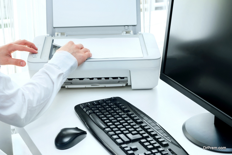 Businessman scans some documents at work using the scanner